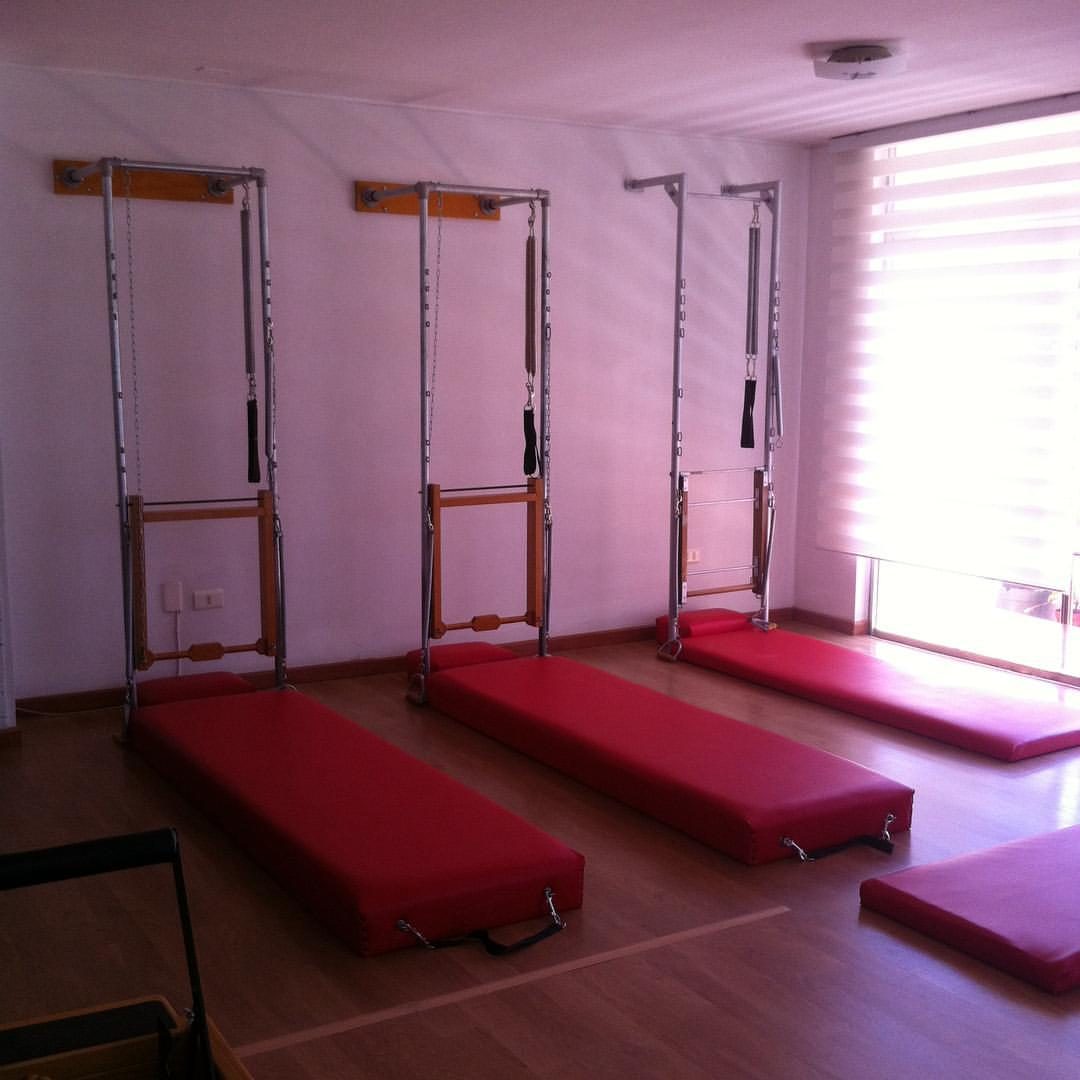 Sala de pilates suelo con camillas frente al ventanal